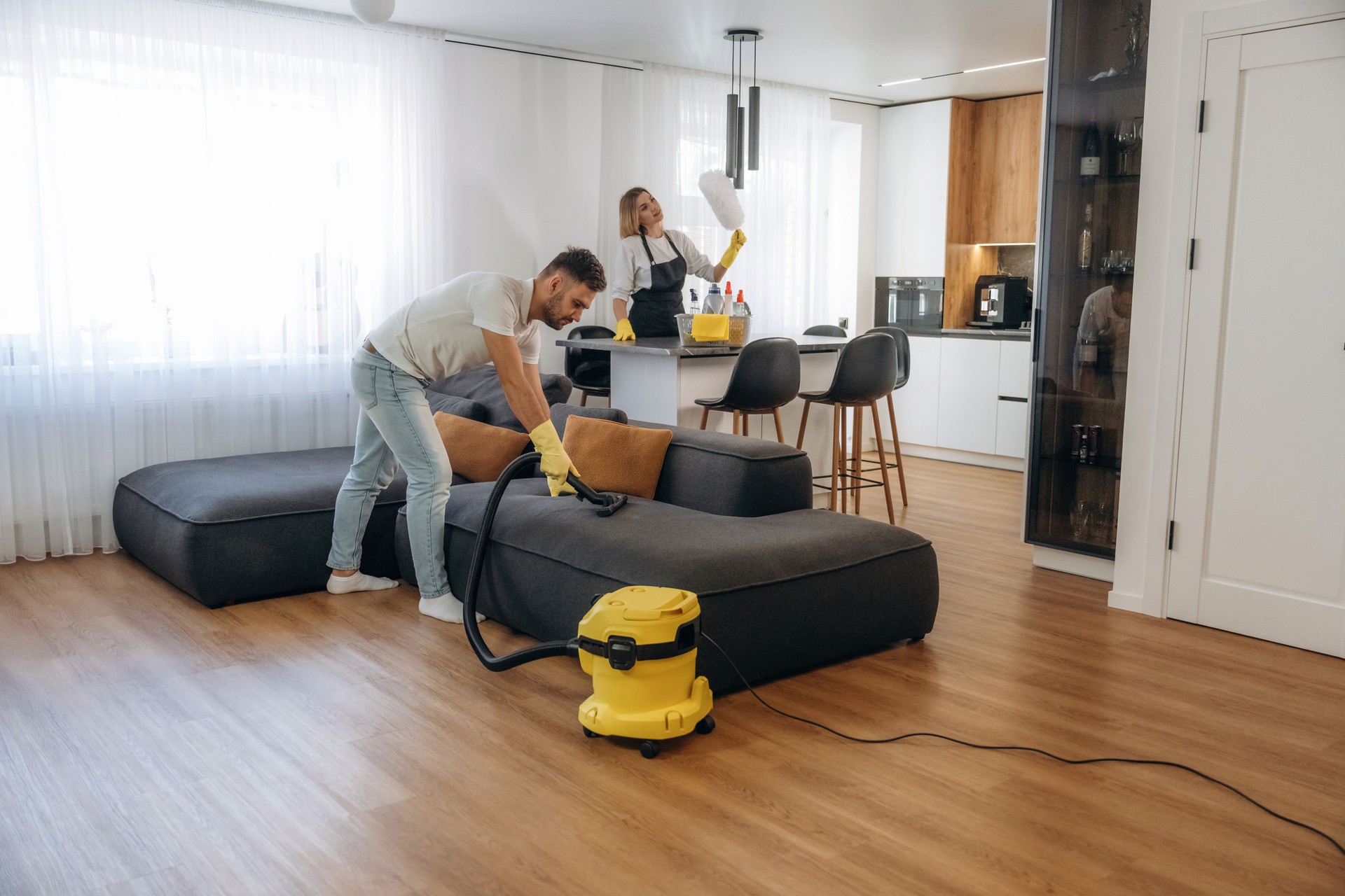 Modern interior of home. Two cleaning service workers are in domestic room